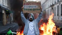 Un encapuchado muestra una pancarta contra el sistema de reparto de las plazas universitarias, en Par�s.