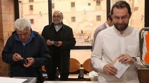 Emilio Le�n, en primer plano, vota, mientras el Arzobispo de Oviedo espera su turno al fondo