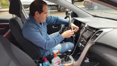 Daniel Mart�nez, de la autoescuela Carbay�n, limpia el interior del veh�culo tras una clase