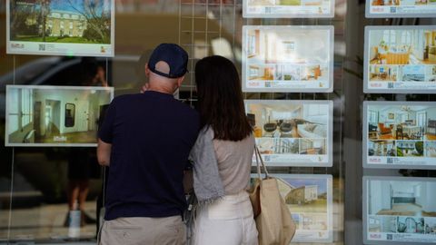 Imagen de archivo de una pareja viendo el escaparate de una inmobiliaria