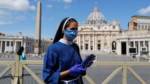 Una monja, ante San Pedro del Vaticano con su telfono en la mano