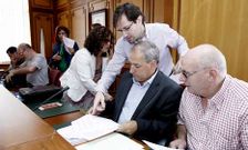 El concejal del PP, Jos� Manuel Puga, charla en el pleno con el portavoz socialista, Jos� Tom�.