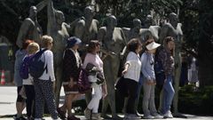 Un grupo de turistas se fotografa con el Monumento a la Concordia de Oviedo