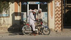 Un hombre recarga su motocicleta en Pakist�n con combustible comprado a Ir�n