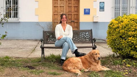 Sara Carpente con su perra, Lis, delante de la entrada principal del edificio, del que destaca �su gran valor hist�rico�