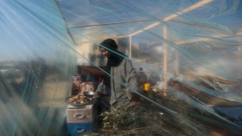 Una palestina desplazada cocina en el interior de una tienda, en un campamento de Rafah.