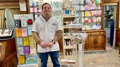 Gonza junto al puesto a favor de Down Asturias en la Farmacia Migoya, en el que vende adornos navideos y calendarios para recaudar fondos.