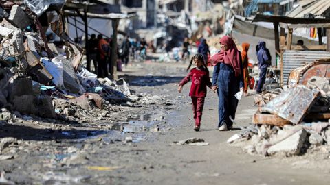 Una mujer y su hija pasean por las ruinas del centro de Gaza.