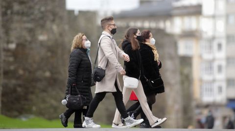 Transentes con mascarilla en una calle de Lugo