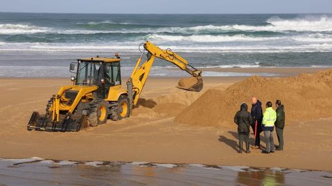 Trabajos de apertura del canal con una excavadora en la playa de Valdovio, que fueron seguidos por el alcalde, Alberto Gonzlez, y otros miembros de la Xunta y el Concello.