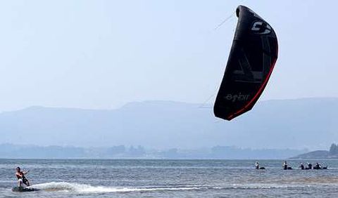 Uno de los monitores demuestra c�mo se cabalga sobre el agua con una cometa bajo la at�nita mirada de las mariscadoras.