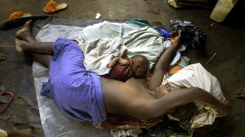 Una mujer de Sierra Leona yace indefensa en el suelo junto a su beb� de seis semanas