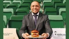 El exjugador del Real Madrid Roberto Carlos con una hamburguesa vegana