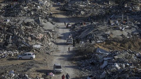 Palestinos inspeccionan edificios destruidos en el campo de refugiados de Rafah.