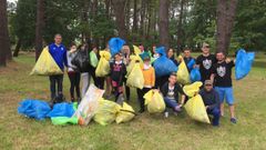 Varios de los grupos de recogida, con el resultado de su trabajo, en el campo da festa de Crendes