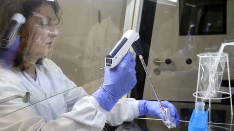 Una investigadora trabaja en el laboratorio de simulación con una cabina de flujo laminar. 