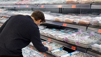 Un cliente elige una bandeja de pescado de la zona de libre servicio de pescader&iacute;a en Mercadona.