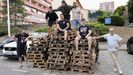 Vecinos del barrio de las Flores, en uno de los montones de palés que les suministran empresas para alimentar la gran hoguera que se instala cada año en la plaza de los Álamos