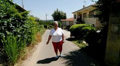 Dolores posa ante el camino que conduce a su vivienda, hoy de titularidad privada.