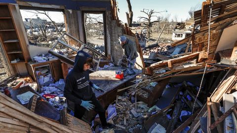 Carson Neeley ayuda a su padre para intentar salvar alguna cosa de su casa devastada por un tornado el pasado 10 de diciembre en Kentucky
