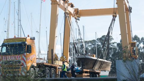 El narcosubmarino, elevado por la gra para su traslado al puerto de Vilagarca.