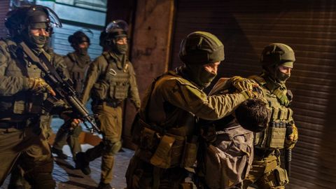 Soldados israel�es detienen a un palestino durante los enfrentamientos de la noche del viernes en la explanada de las Mezquitas