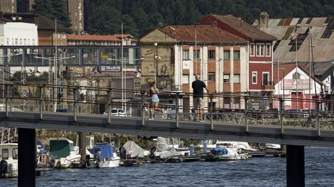 Una mujer cruzando sobre un puente sobre la ría de Avilés 