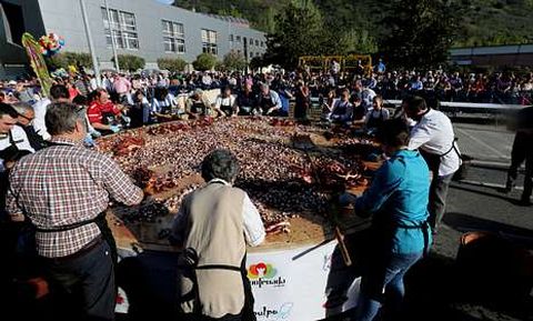 Los participantes en la convocatoria repartiendo el pulpo por la tapa.