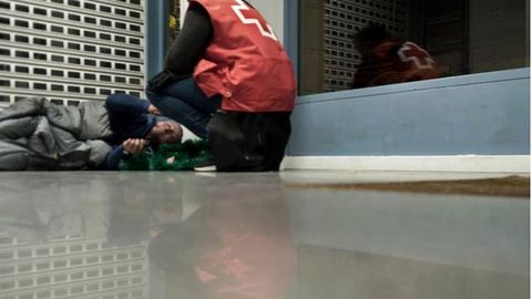 Un voluntario atiende a una persona sin techo