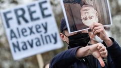 Un manifestante muestra una fotografia de Putin en una marcha en Berlin para exigir la libertad de Navalni