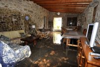 Interior de la casa con el suelo embarrado y filtraciones de agua.