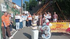 Los vecinos del barrio de Freixeiro con la tarta del tercer aniversario del muro apuntalado