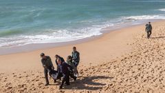 Agentes de la Guardia Civil y operarios, trasladan un cad�ver de los ocupantes de la patera que naufrag� en el 2018 en la playa de Ca�os de Meca (C�diz)