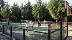 Nios jugando en una pista deportiva del polgono de San Cibrao das Vias.