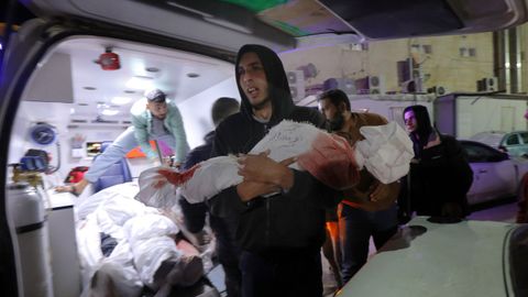 Familiares de palestinos que murieron en ataques israel�es lloran al recibir los cad�veres de la morgue del hospital Al-Aqsa.