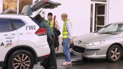 Un agente de la Guardia Civil abandona el domicilio de O Grove registrado, empu�ando la guitarra el�ctrica roja