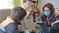 Carmen Cebreiro junto a dos voluntarios de Protecci�n Civil, que le ayudaron a contactar con parte de su familia en Palma de Mallorca