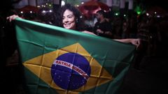 Una mujer sostiene una bandera de Brasil mientras celebra la condena a Bolsonaro en una calle de Brasilia