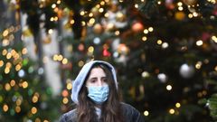 Una joven pasa junto a un �rbol de Navidad en Londres