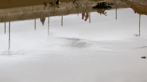 Reflejo de la gente cruzando por el barranco del Poyo a su paso por Paiporta, Valencia