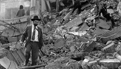 Un hombre anda sobre los escombros de la sede de la AMIA, derruida por la explosi�n. 