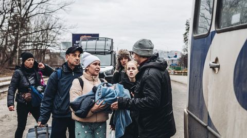 Una familia, con un beb, intentando huir de la ciudad