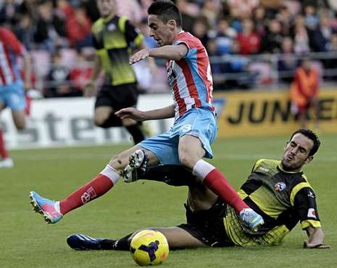 Iago D�az, con el cuero, trata de esquivar la entrada de un futbolista del Sabadell.