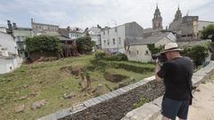 Un turista fotografiando este 24 de junio el Pazo de Dona Urraca y el �rea donde se va a intervenir, junto a la Muralla de Lugo