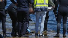 Los agentes recogen la pistola que encontraron en aguas de Ribeira