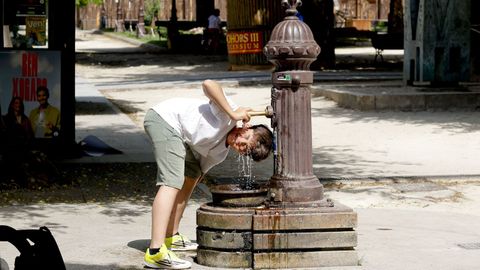 Un lucense intenta refrescarse en una fuente del centro de la ciudad.