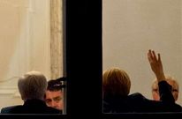 Merkel, de espaldas, hace un gesto que llama la atenci�n del l�der del SPD, Sigmar Gabriel.