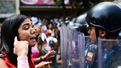 Una partidaria de Guaid� se enfrenta a un miembro de la Polic�a Bolivariana durante la manifestaci�n de ayer en Caracas