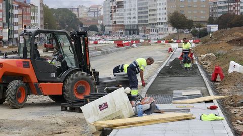 Operarios componiendo una de las aceras en O Bertn el pasado viernes.