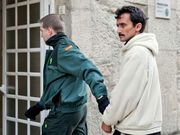 Traslado de un detenido, esposado, ante la jueza.